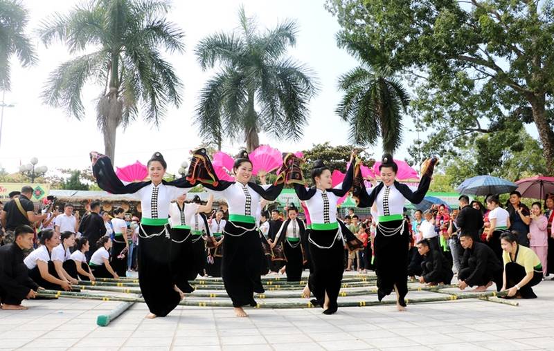 Local residents guide tourists in participating in the bamboo pole dance 