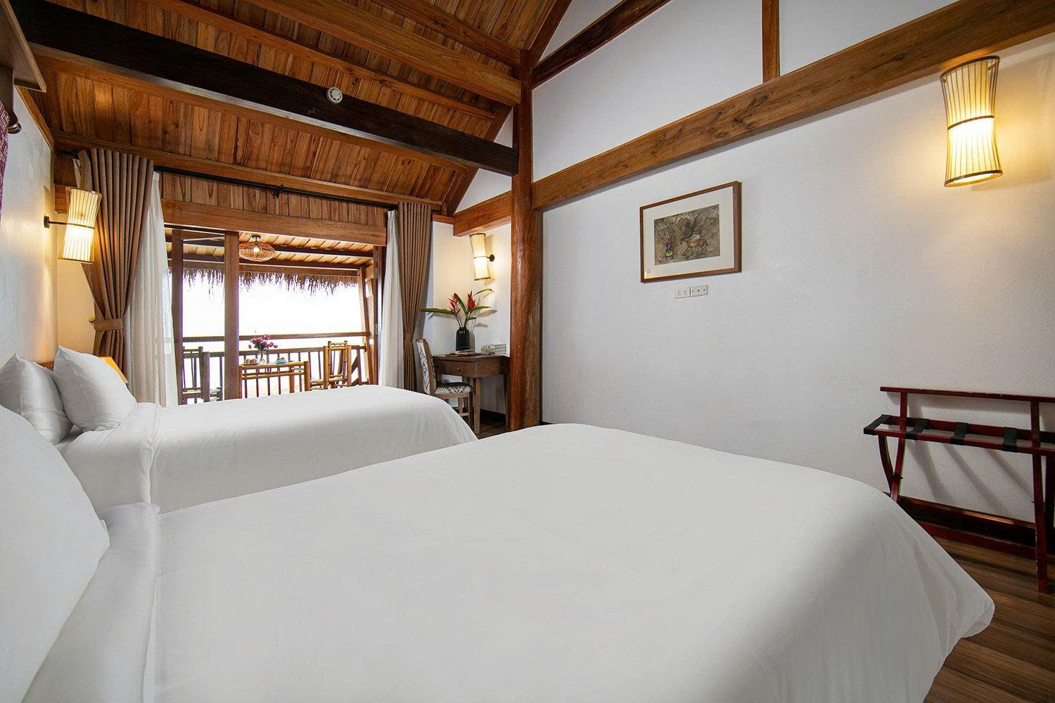Cozy guest room at Mai Chau Hideaway Lake Resort featuring natural wooden architecture and paintings by artist Do Duc 