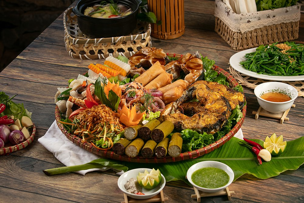 Co la, a traditional Muong communal feast served on fresh leaves, features local meats and vegetables