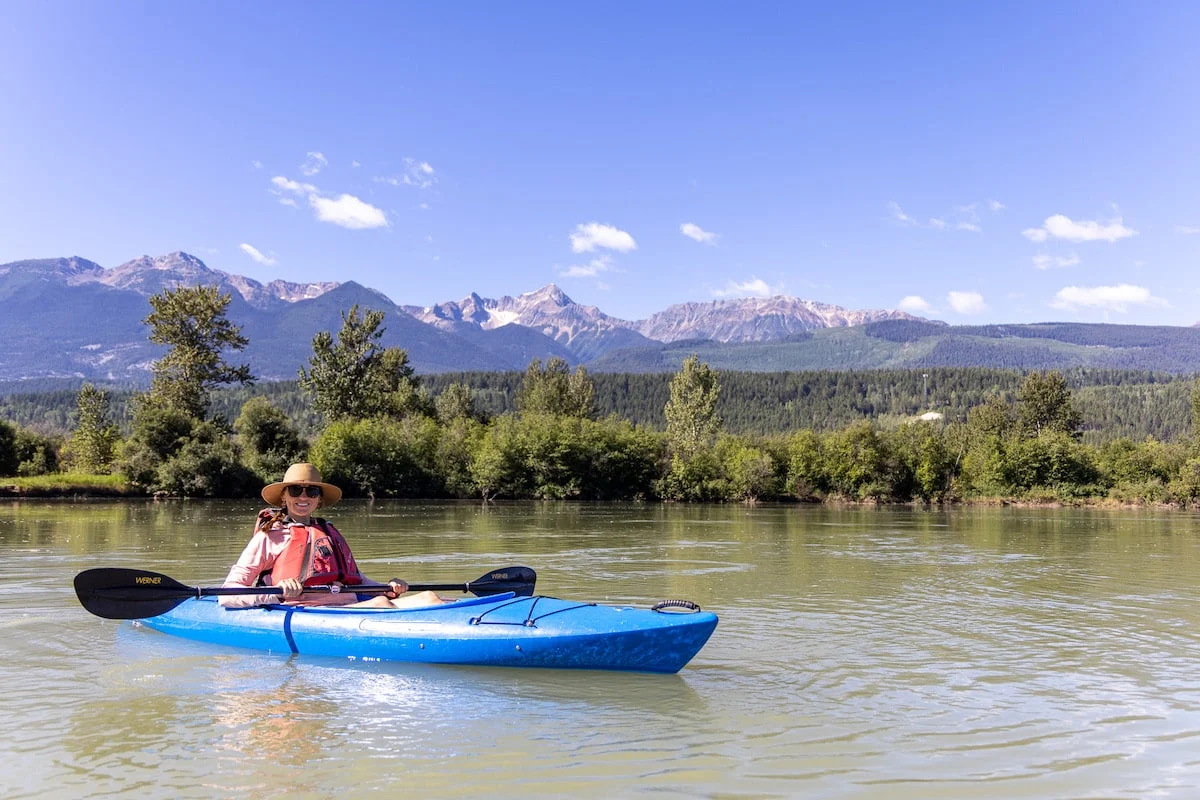 A kayak at a wooden dock while a guest steps in, illustrating the assisted, low-risk entry technique (Source: Bearfoot Theory)