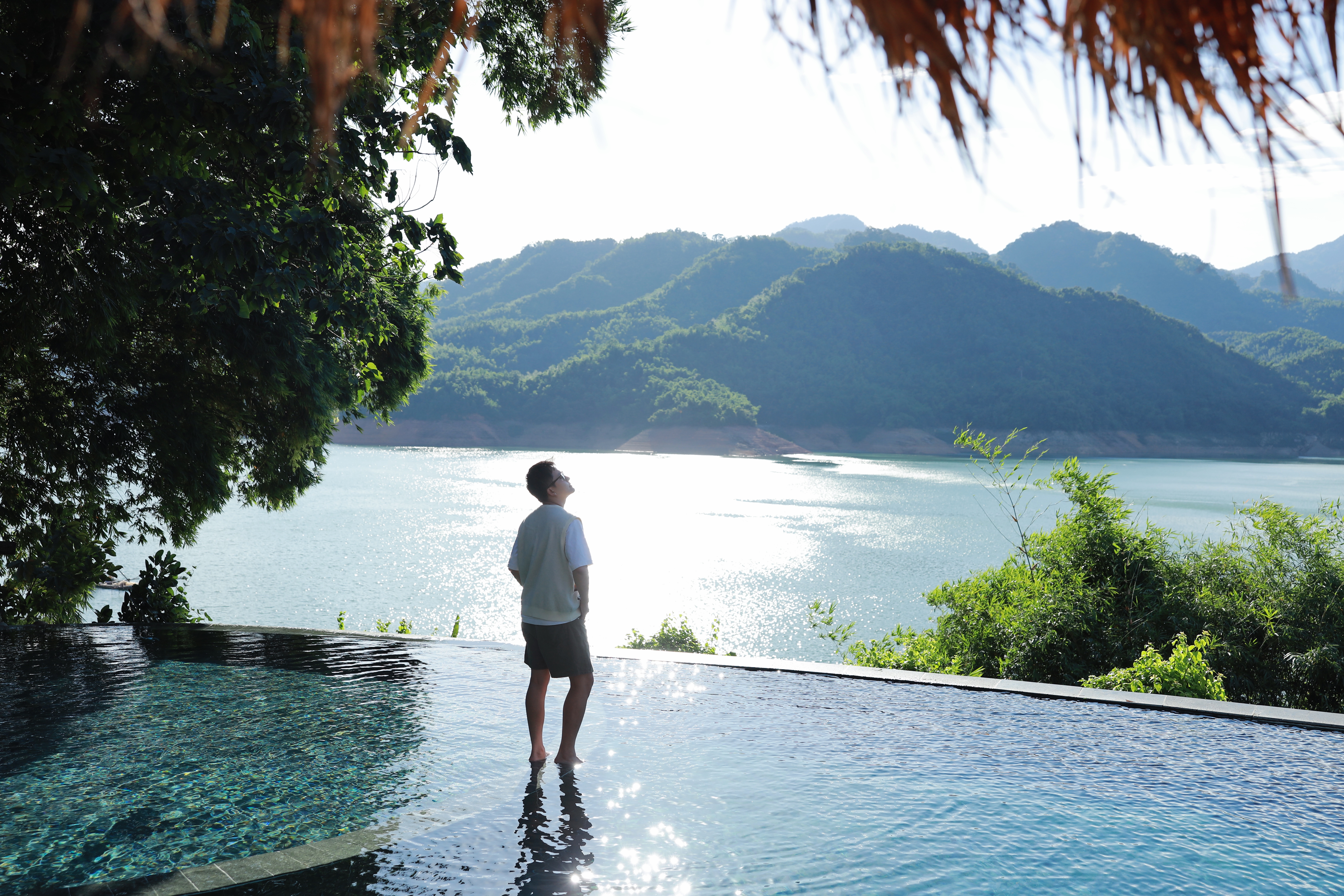 The infinity pool at Mai Chau Hideaway Lake Resort sits at the lake's edge, blending pool water and lake water into one view
